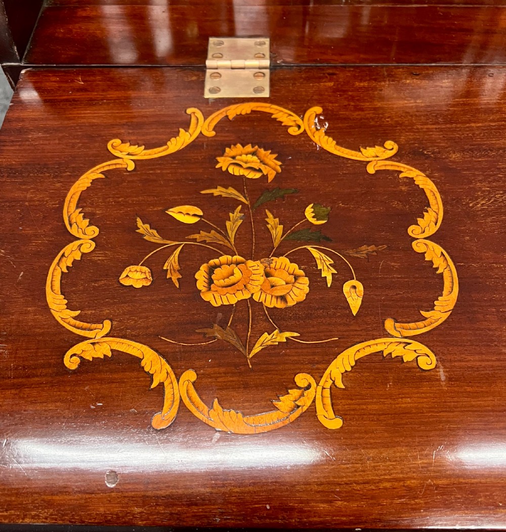 An antique Dutch marquetry writing bureau crafted from mahogany with detailed floral wood inlays, brass drop handles, and claw feet. View X