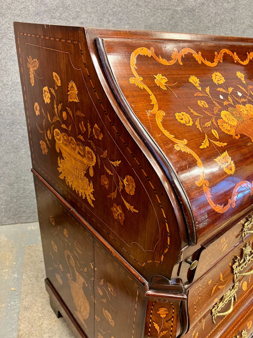 An antique Dutch marquetry writing bureau crafted from mahogany with detailed floral wood inlays, brass drop handles, and claw feet. View XV