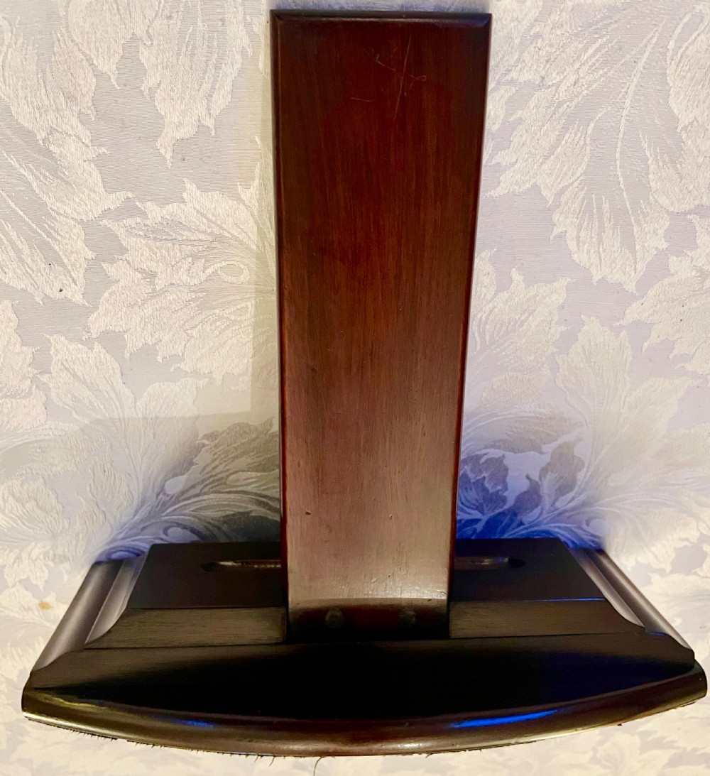 A dark polished mahogany weighted plate stand featuring a stepped moulded base with a central groove and a vertical upright backboard. View V
