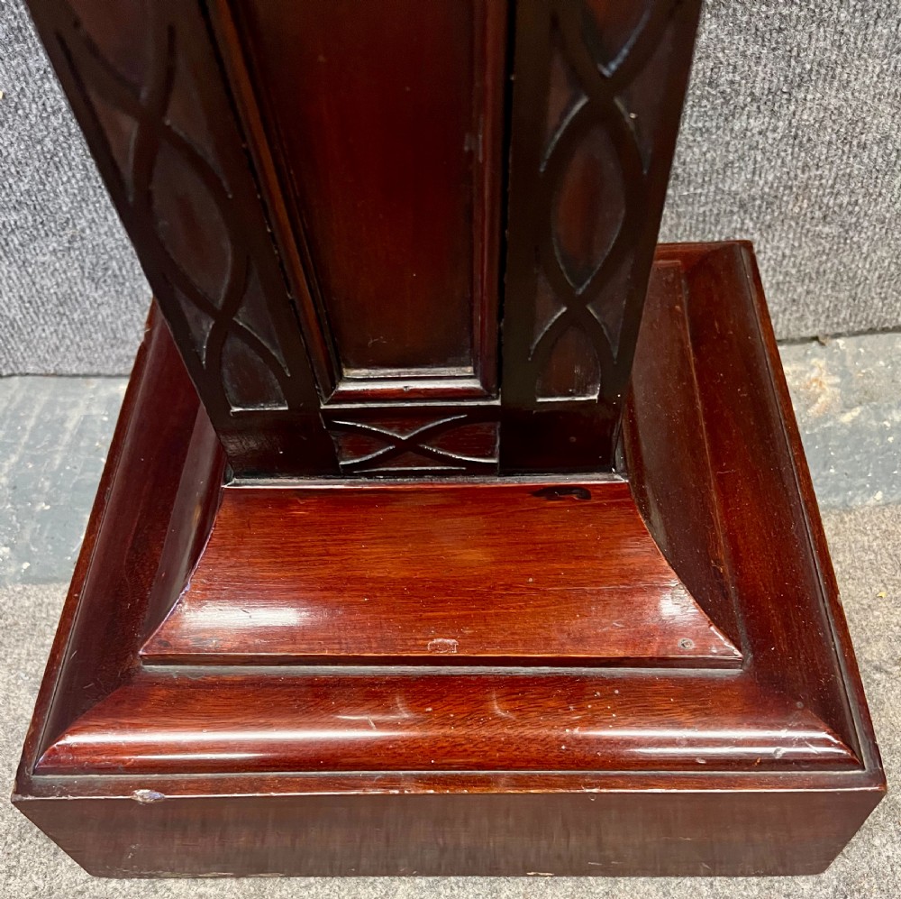 A tall, tapered mahogany pedestal featuring a square moulded top, carved strapwork border details, and a stepped plinth base. View III