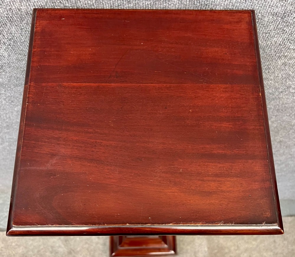 A tall, tapered mahogany pedestal featuring a square moulded top, carved strapwork border details, and a stepped plinth base. View V