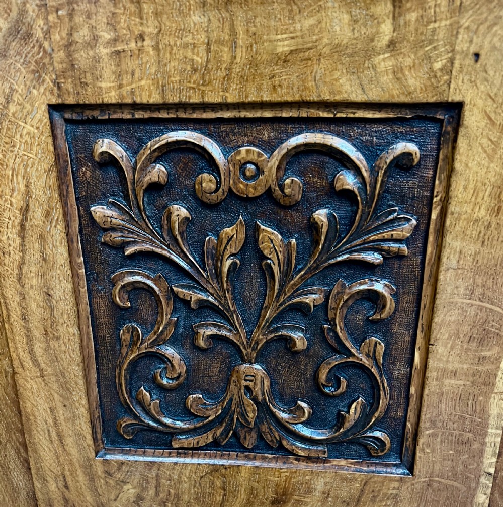 A two-tier Victorian pollard oak secretaire bookcase featuring upper glazed doors with books above a lower cabinet with carved relief panels. View XII