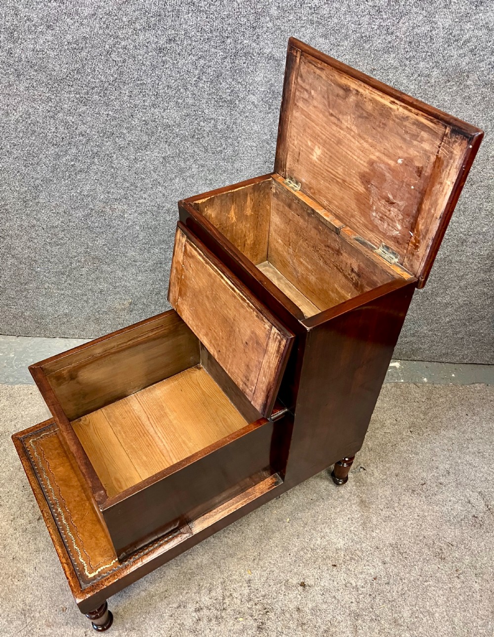 A set of three dark mahogany library steps featuring gold-tooled tan leather treads and turned wooden legs. View II