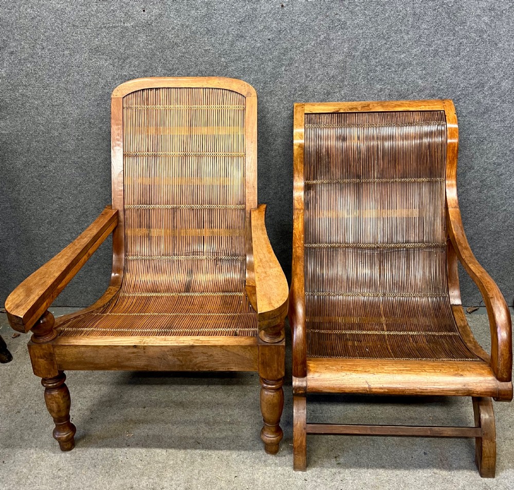 A pair of teak plantation chairs with reclining frames, woven split cane backs and seats, turned front legs, and flat extended armrests. View III
