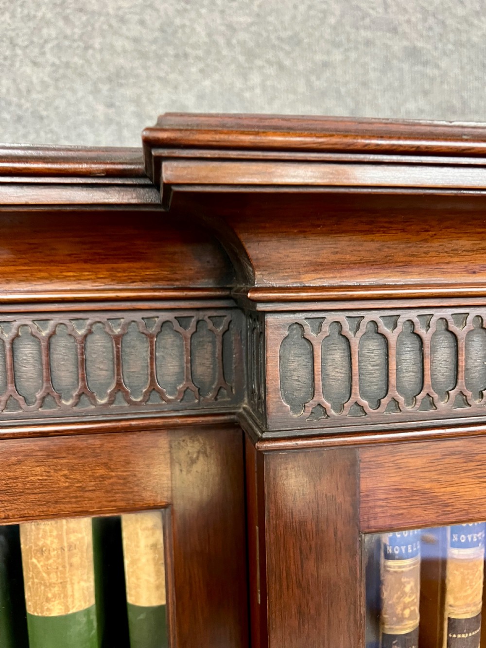 A large mahogany breakfront bookcase featuring four lattice-glazed upper doors above four panelled lower cupboard doors. View V