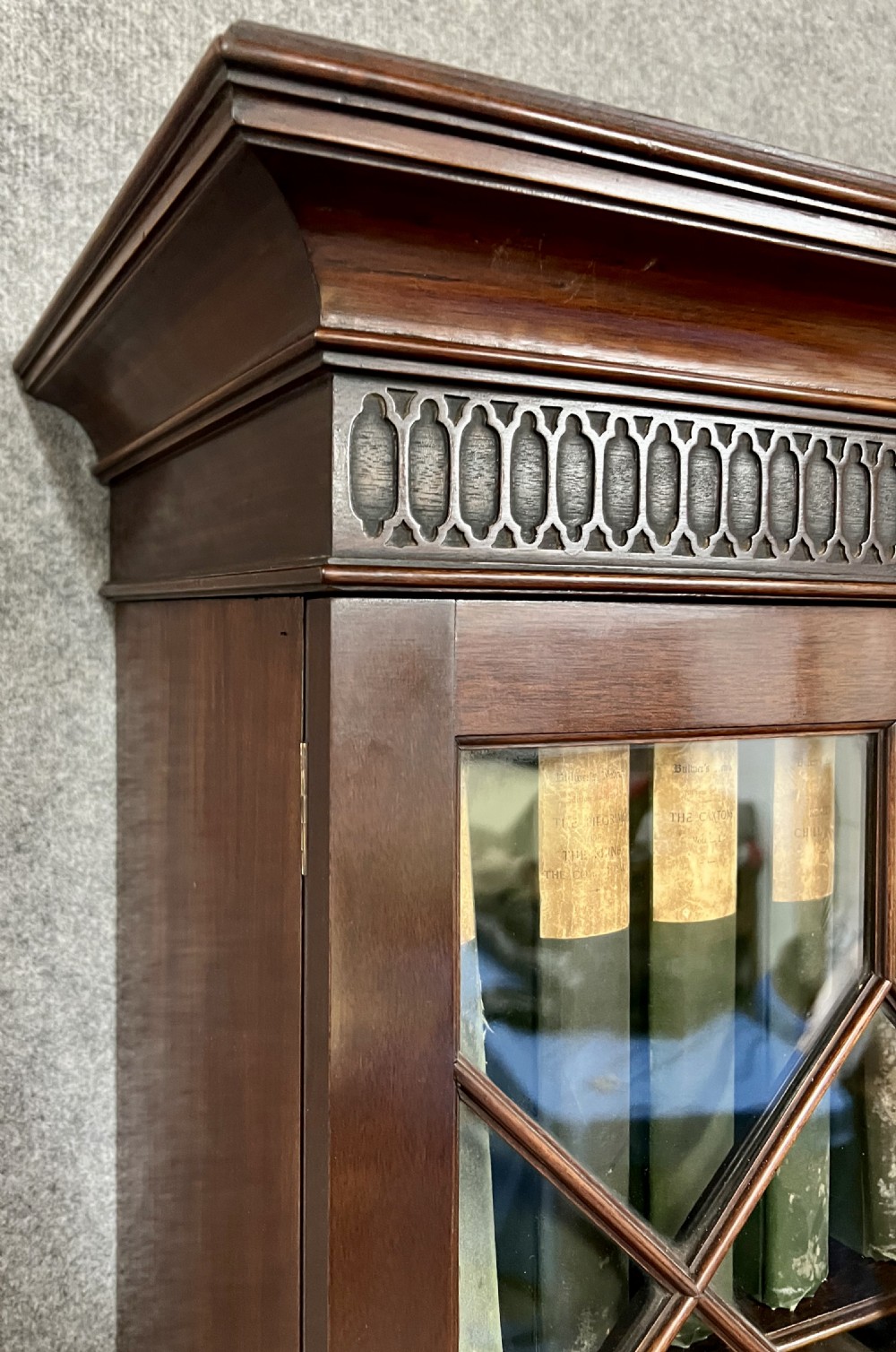 A large mahogany breakfront bookcase featuring four lattice-glazed upper doors above four panelled lower cupboard doors. View VI