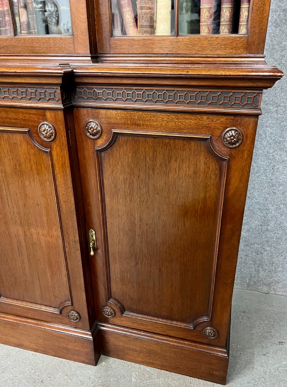 A large mahogany breakfront bookcase featuring four lattice-glazed upper doors above four panelled lower cupboard doors. View VIII