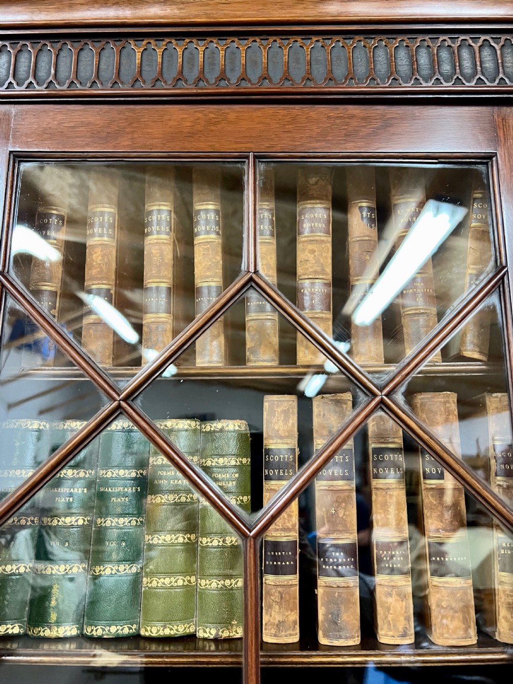 A large mahogany breakfront bookcase featuring four lattice-glazed upper doors above four panelled lower cupboard doors. View XIII