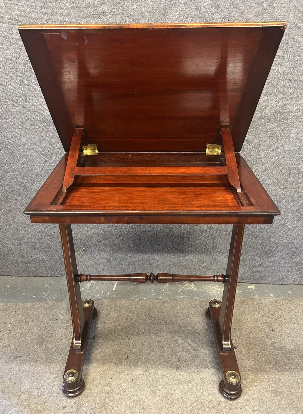 A Regency mahogany adjustable reading table with brass inlay and a gold tooled leather tilting top. View II