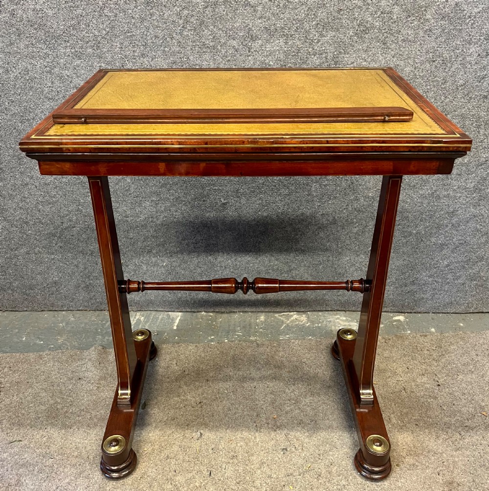 A Regency mahogany adjustable reading table with brass inlay and a gold tooled leather tilting top. View XI