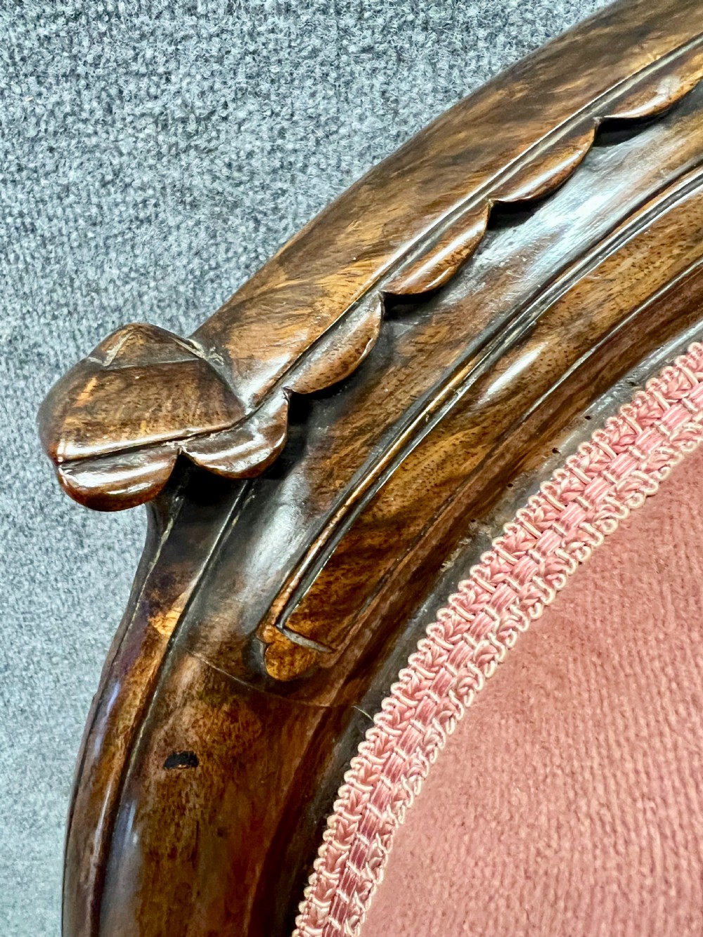 A Victorian open armchair crafted from carved dark walnut with button-backed rose pink velvet upholstery and brass castors. View XII