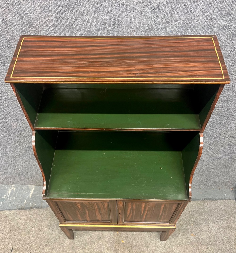 A Regency style dark wood waterfall bookcase featuring two open green-painted shelves over a double-door lower cabinet on tapered legs. View VIII
