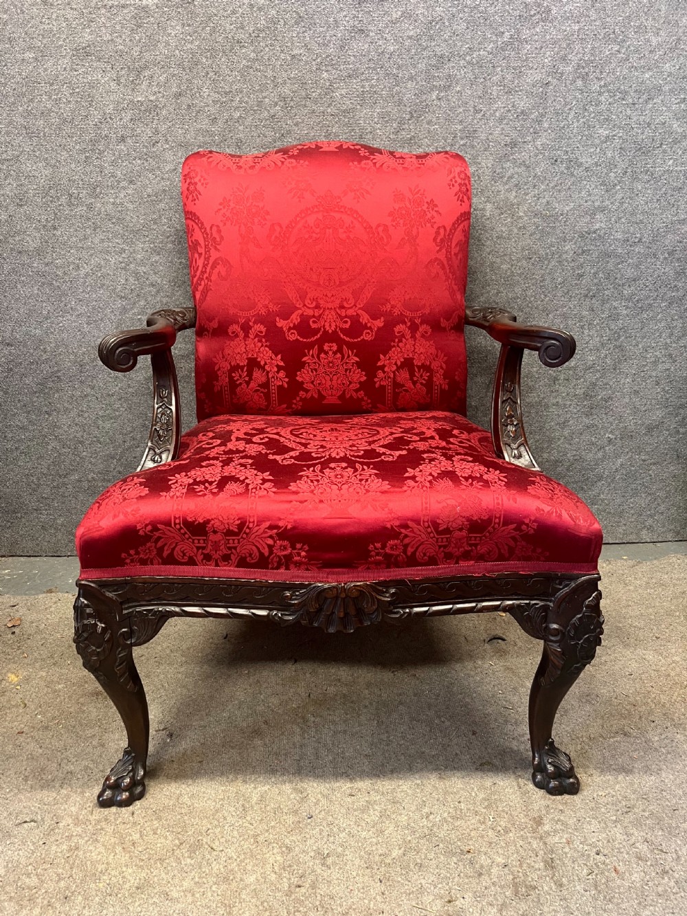 A 19th-century mahogany Gainsborough library chair upholstered in patterned crimson red damask, featuring carved cabriole legs and claw and ball feet. View II