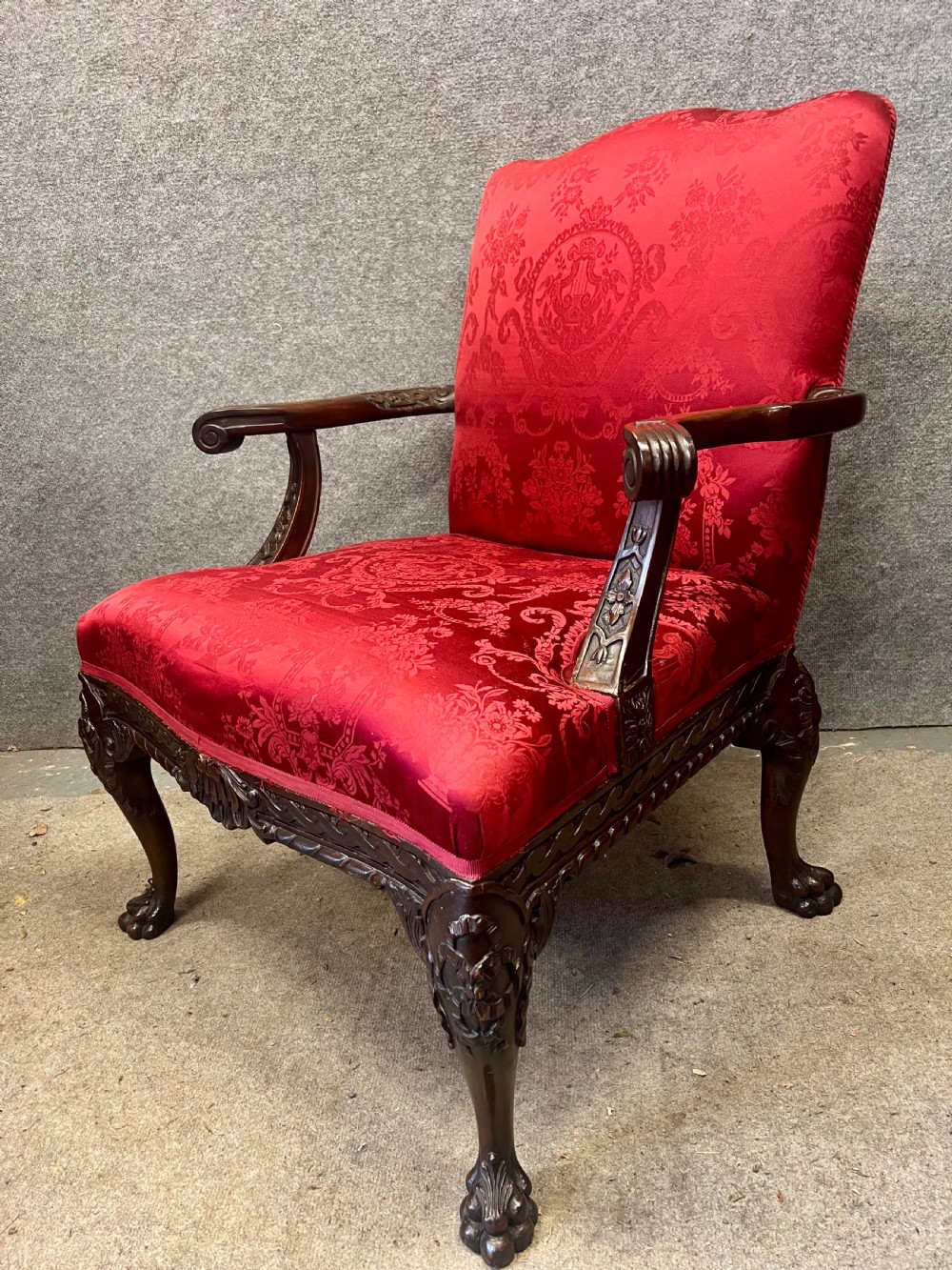 A 19th-century mahogany Gainsborough library chair upholstered in patterned crimson red damask, featuring carved cabriole legs and claw and ball feet. View V