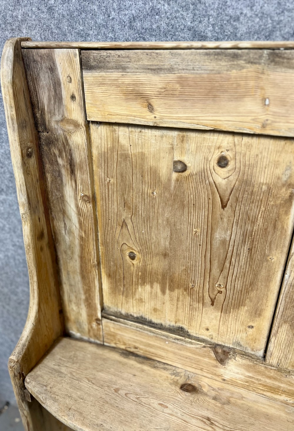 An antique light pine wooden settle featuring a high three-panel backrest, flat plank seat, and solid shaped side supports. View II