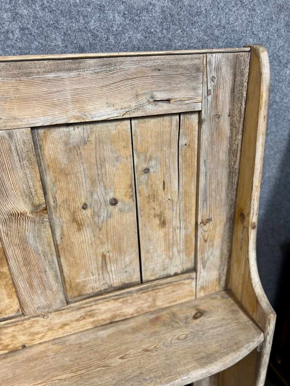 An antique light pine wooden settle featuring a high three-panel backrest, flat plank seat, and solid shaped side supports. View IV