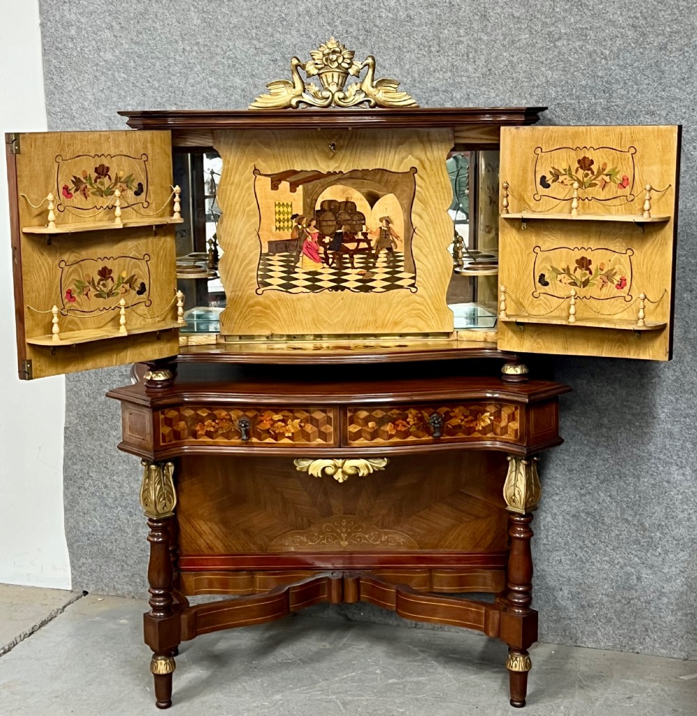 A two-tier dark walnut cocktail cabinet featuring intricate floral marquetry, a serpentine front, gilded carved accents, and turned legs with a contoured stretcher. View IV