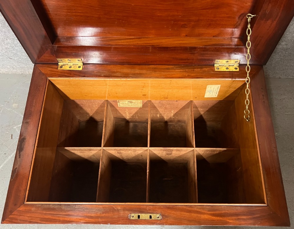 A sarcophagus-shaped antique mahogany wine cellarette with a flared lid, tapered sides, and carved turned feet. View V