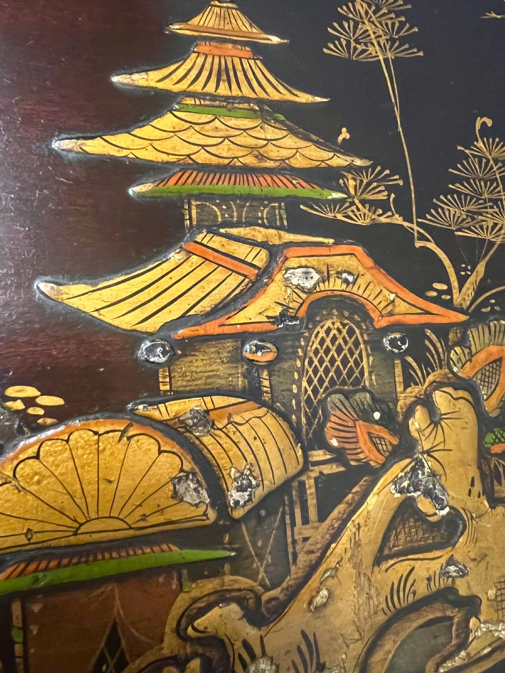 A dark lacquered bow-front Chinoiserie cabinet featuring gilded pictorial landscapes and cabriole legs. View IX