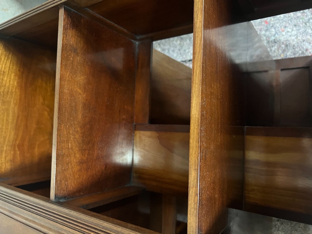 A four-sided warm brown wooden revolving bookcase featuring multiple tiers of open shelving, corner panel details, and a moulded top cornice. View V