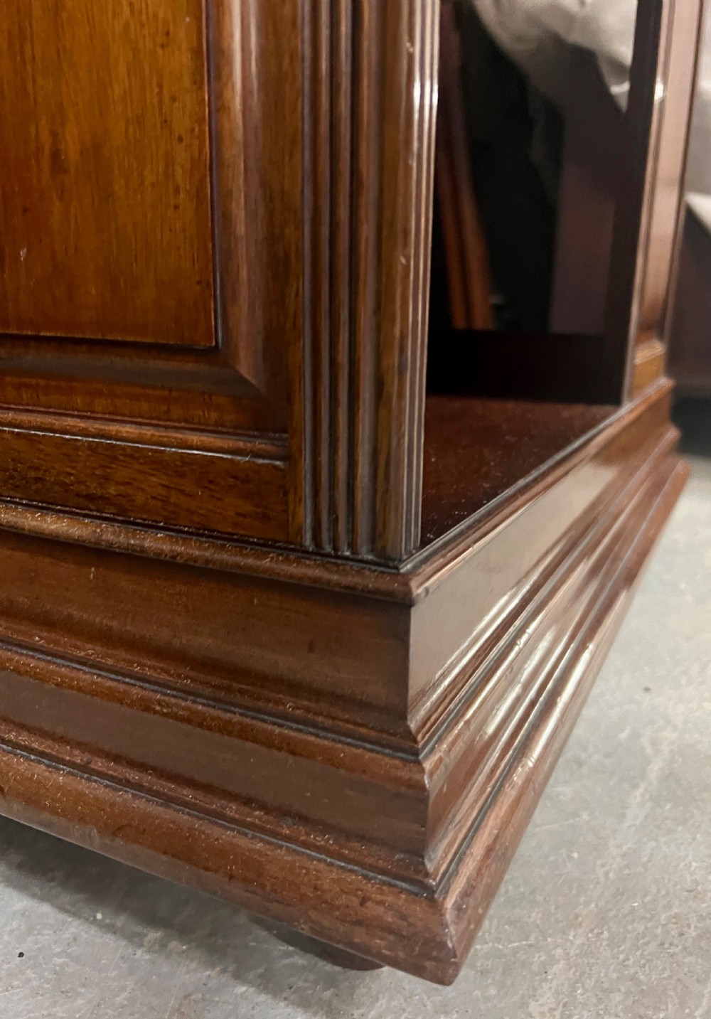 A four-sided warm brown wooden revolving bookcase featuring multiple tiers of open shelving, corner panel details, and a moulded top cornice. View VI