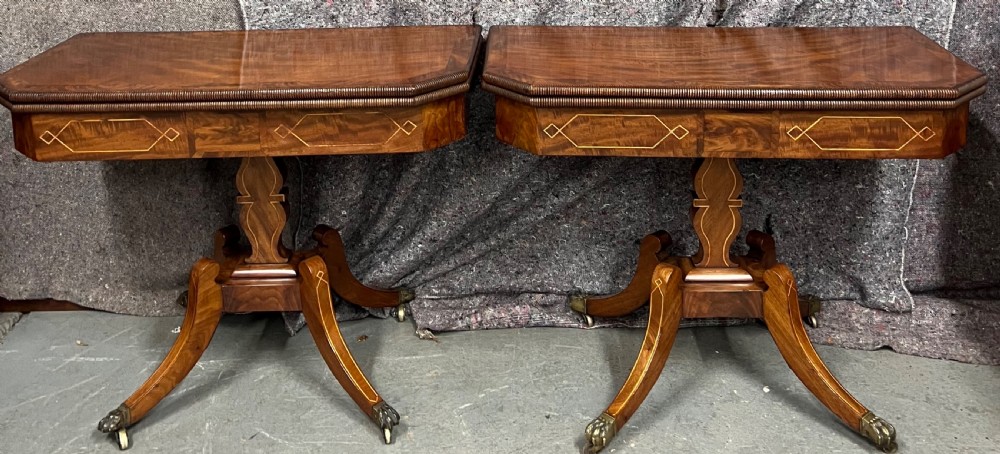 A pair of Regency flame mahogany fold-over card tables featuring boxwood inlay, reeded edges, and pedestal bases with splayed legs ending in brass paw castors. View II