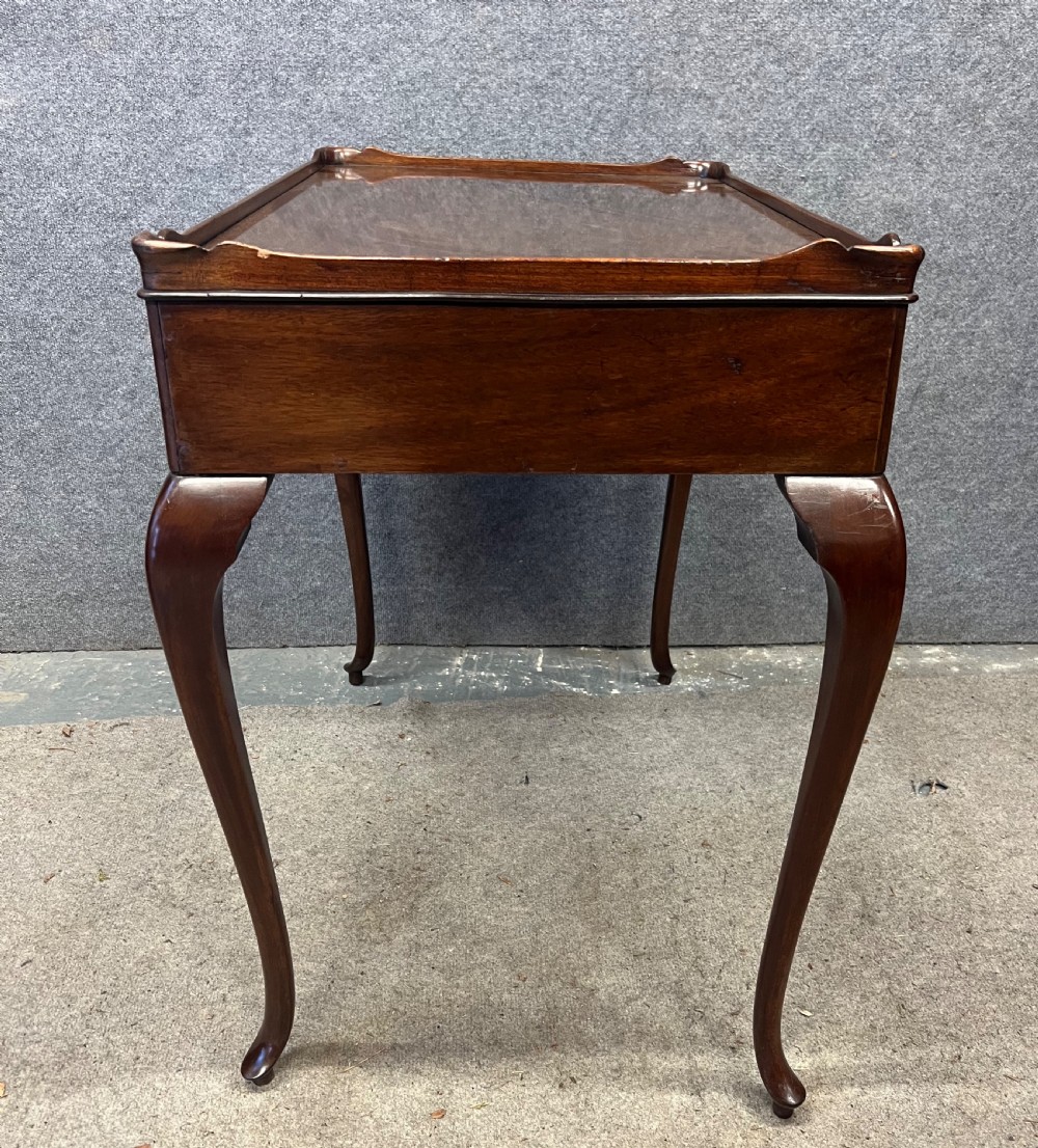 A Georgian mahogany silver table featuring a raised gallery top, a single drawer with brass handles, and slender cabriole legs. View VI