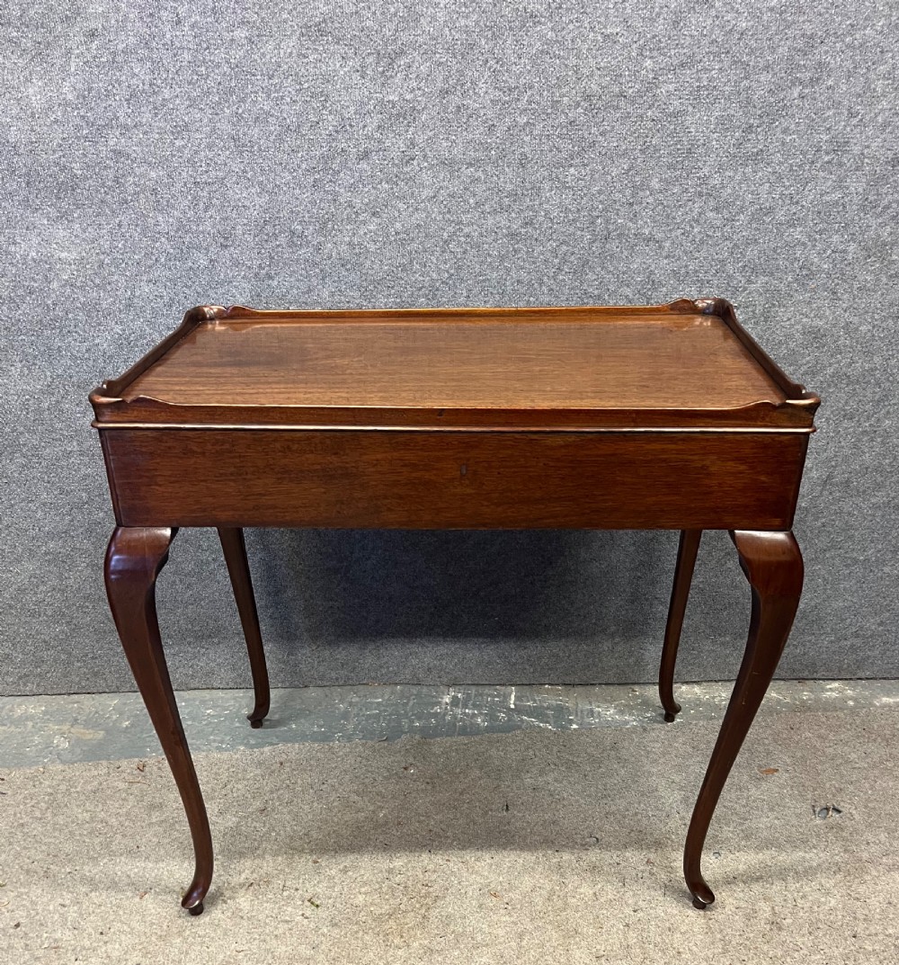 A Georgian mahogany silver table featuring a raised gallery top, a single drawer with brass handles, and slender cabriole legs. View VII
