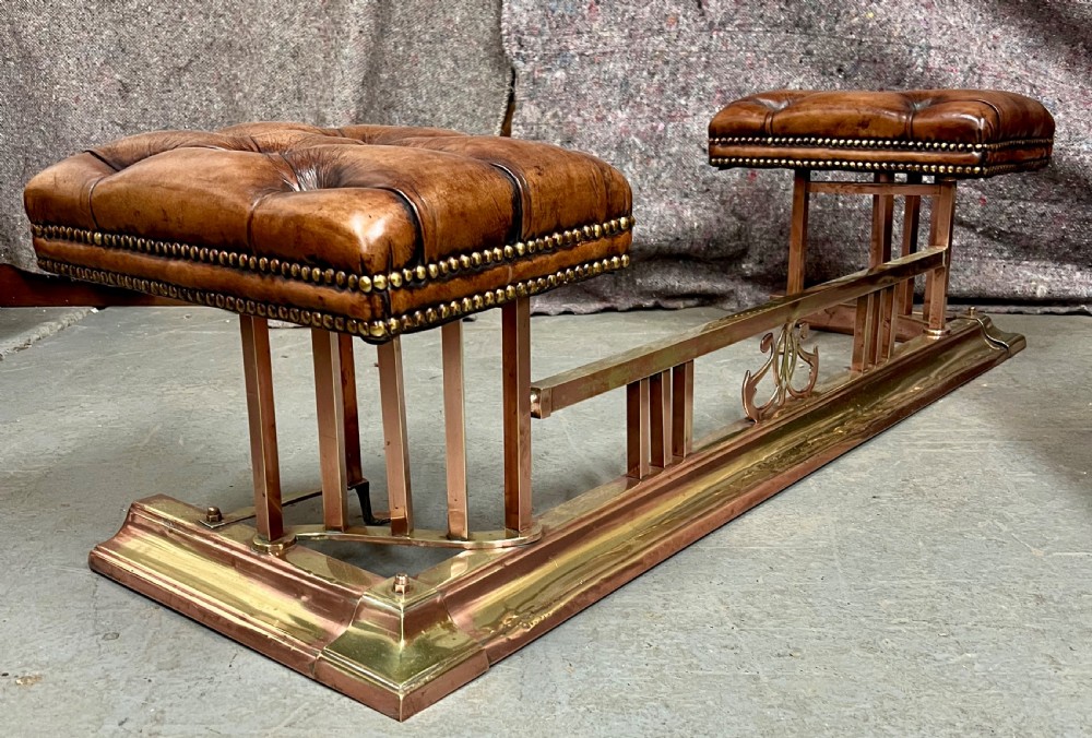 An antique brass and copper club fender featuring two button-tufted brown leather corner seats with brass stud detailing set on a low metal base. View II