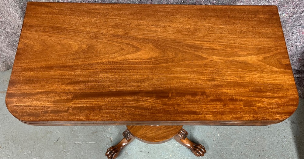A pair of antique flame mahogany fold-over console tables featuring central carved pedestal columns and claw feet with castors. View III