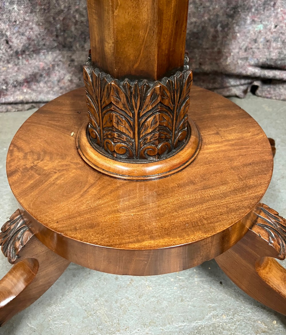 A pair of antique flame mahogany fold-over console tables featuring central carved pedestal columns and claw feet with castors. View V