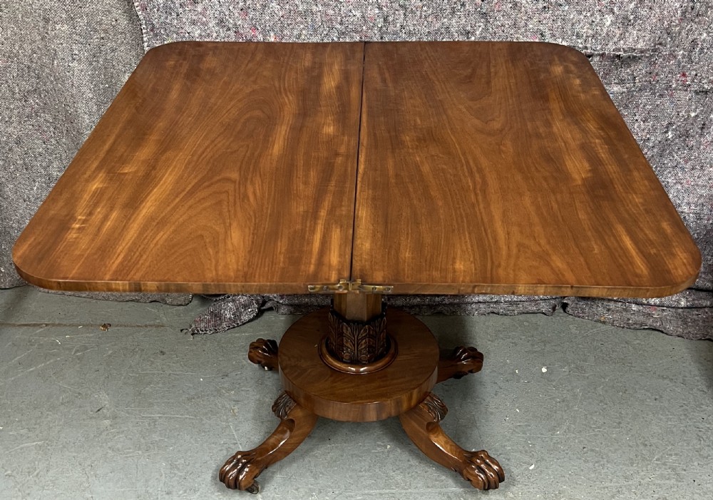 A pair of antique flame mahogany fold-over console tables featuring central carved pedestal columns and claw feet with castors. View VI
