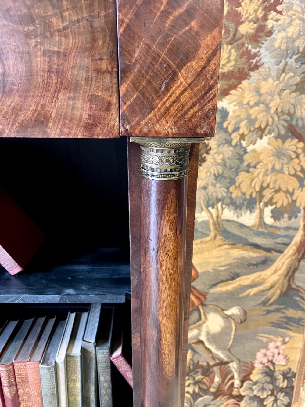 An antique French Empire open bookcase crafted from flame mahogany, featuring three open shelves, a top frieze drawer, and side column supports. View IV