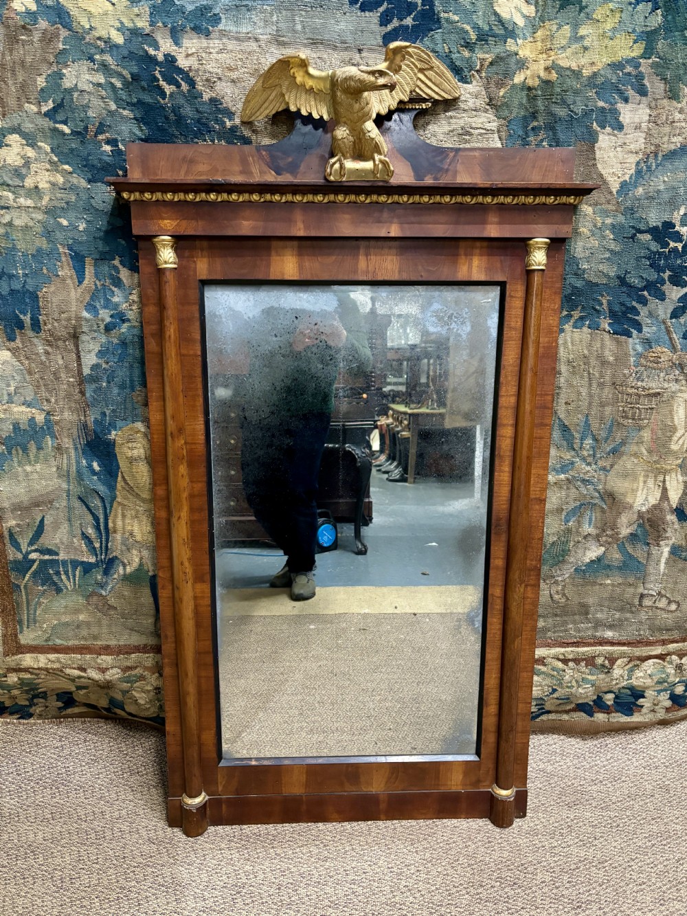 A rectangular Regency mahogany wall mirror with a carved gilded eagle cresting mounted at the top centre.