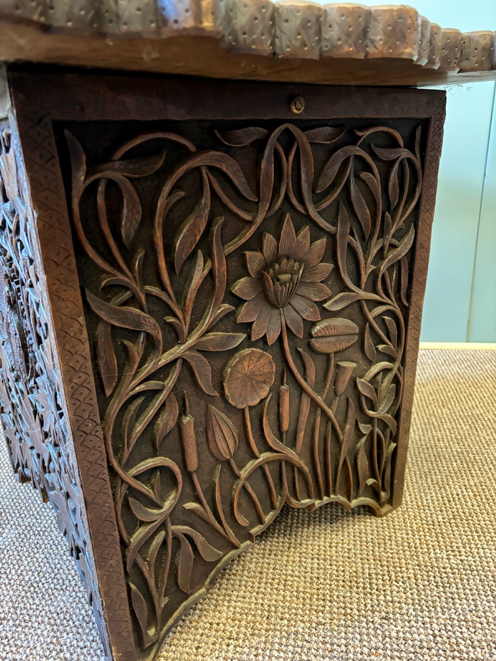 A square dark hardwood side table featuring intricate relief carvings of lotus flowers and foliage across the top and side panels. View II