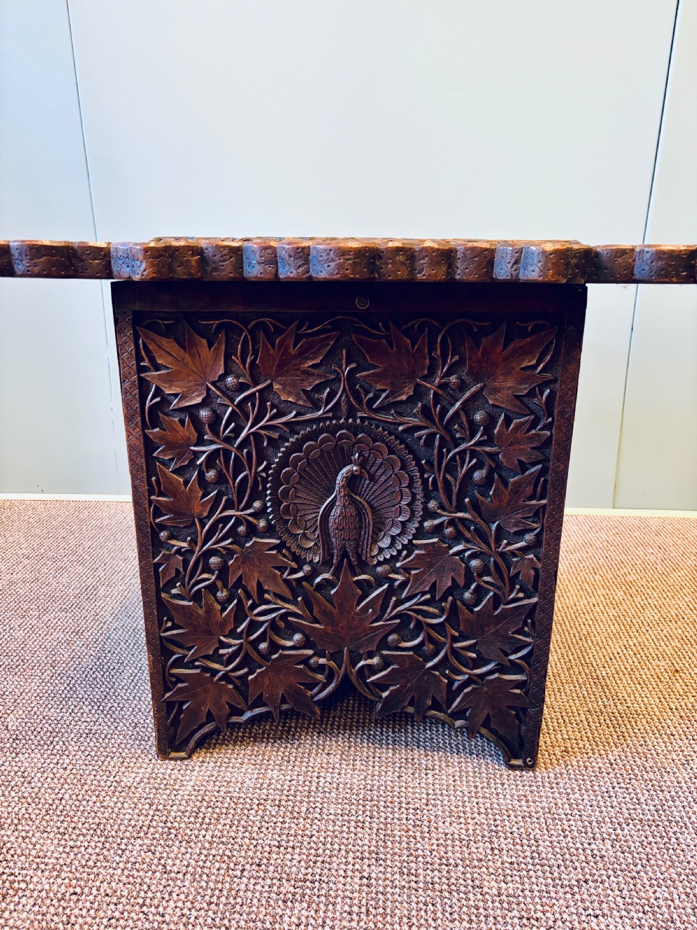 A square dark hardwood side table featuring intricate relief carvings of lotus flowers and foliage across the top and side panels. View III