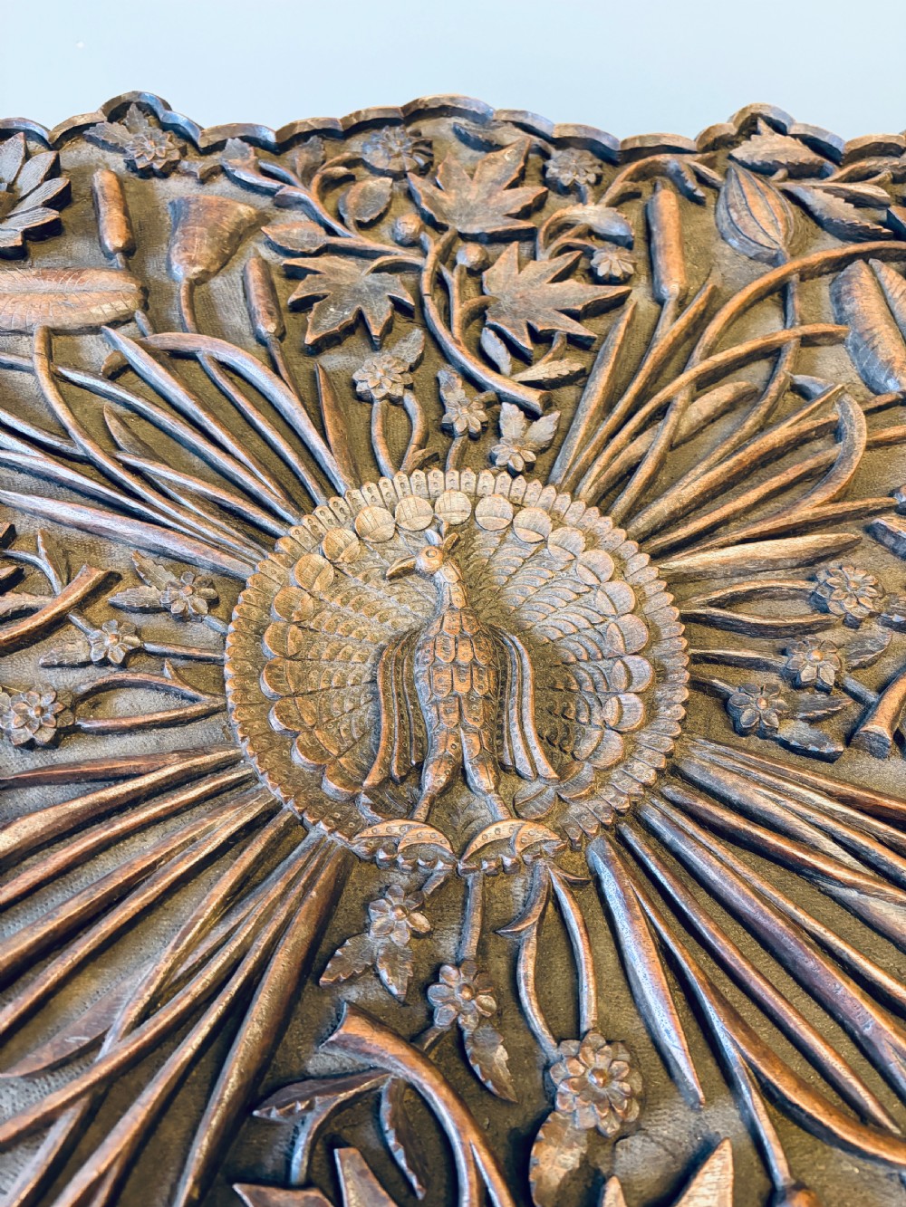 A square dark hardwood side table featuring intricate relief carvings of lotus flowers and foliage across the top and side panels. View VIII