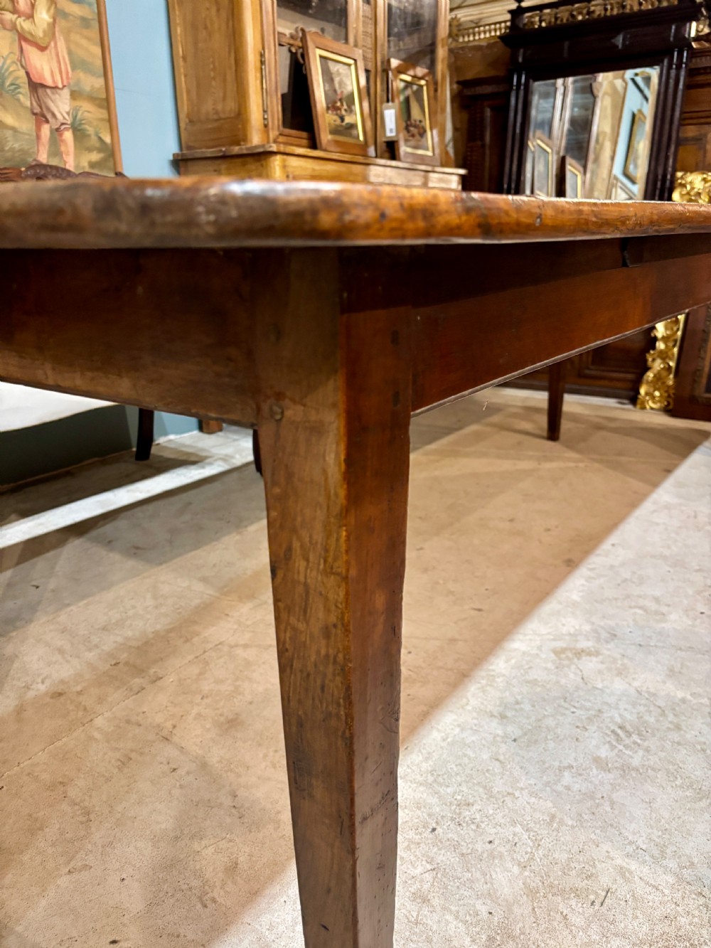 A long 19th-century French farmhouse dining table in warm brown wood with a polished plank top and square tapered legs. View IV