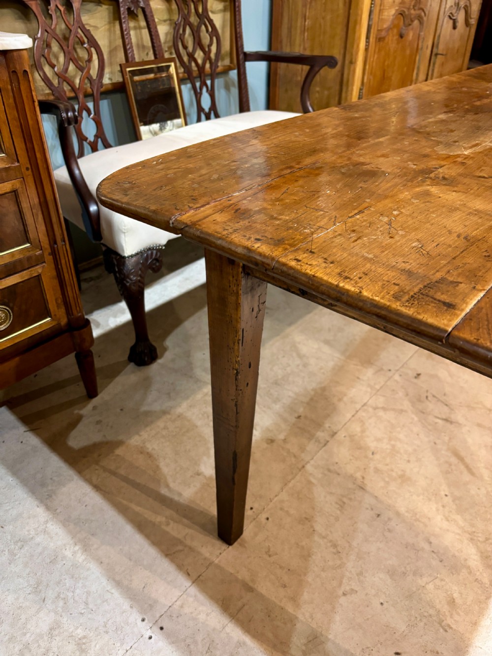 A long 19th-century French farmhouse dining table in warm brown wood with a polished plank top and square tapered legs. View XI