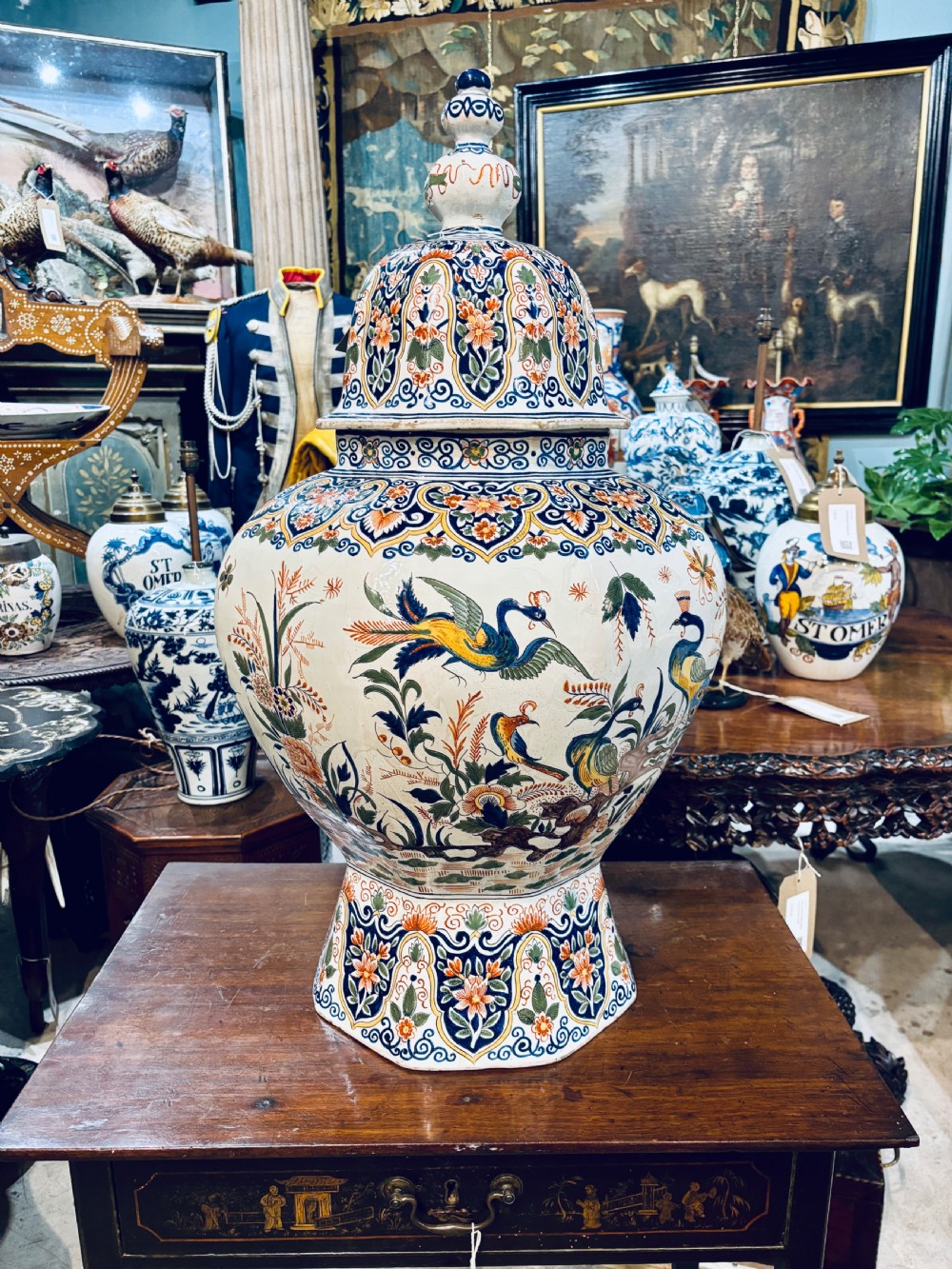 A large 19th-century polychrome Delft lidded jar decorated with hand-painted bird and floral patterns, featuring a domed lid with a finial.