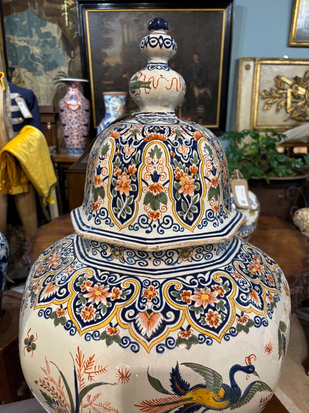 A large 19th-century polychrome Delft lidded jar decorated with hand-painted bird and floral patterns, featuring a domed lid with a finial. View IV