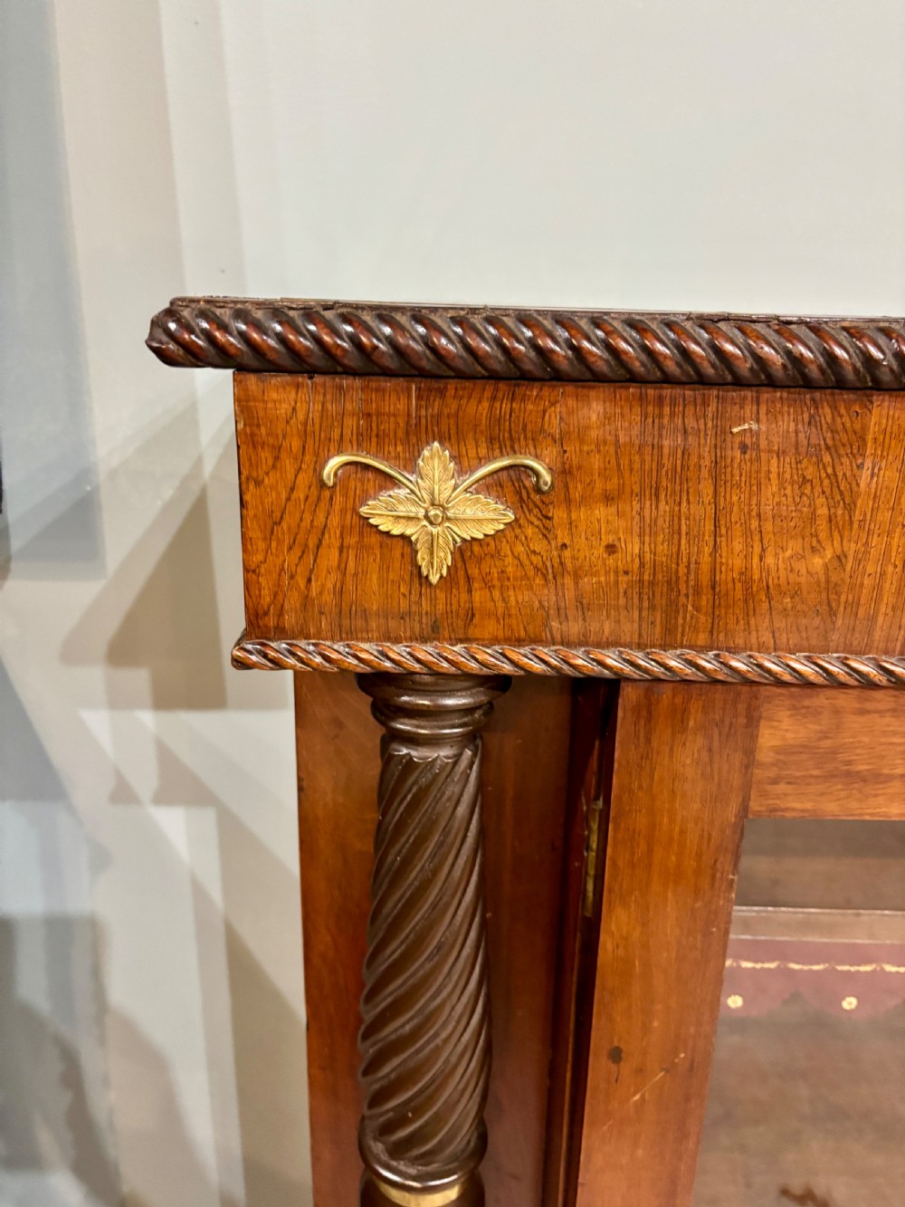 A 19th-century low rosewood bookcase featuring twin glazed doors flanked by spiral columns and decorated with brass rosette mounts. View II