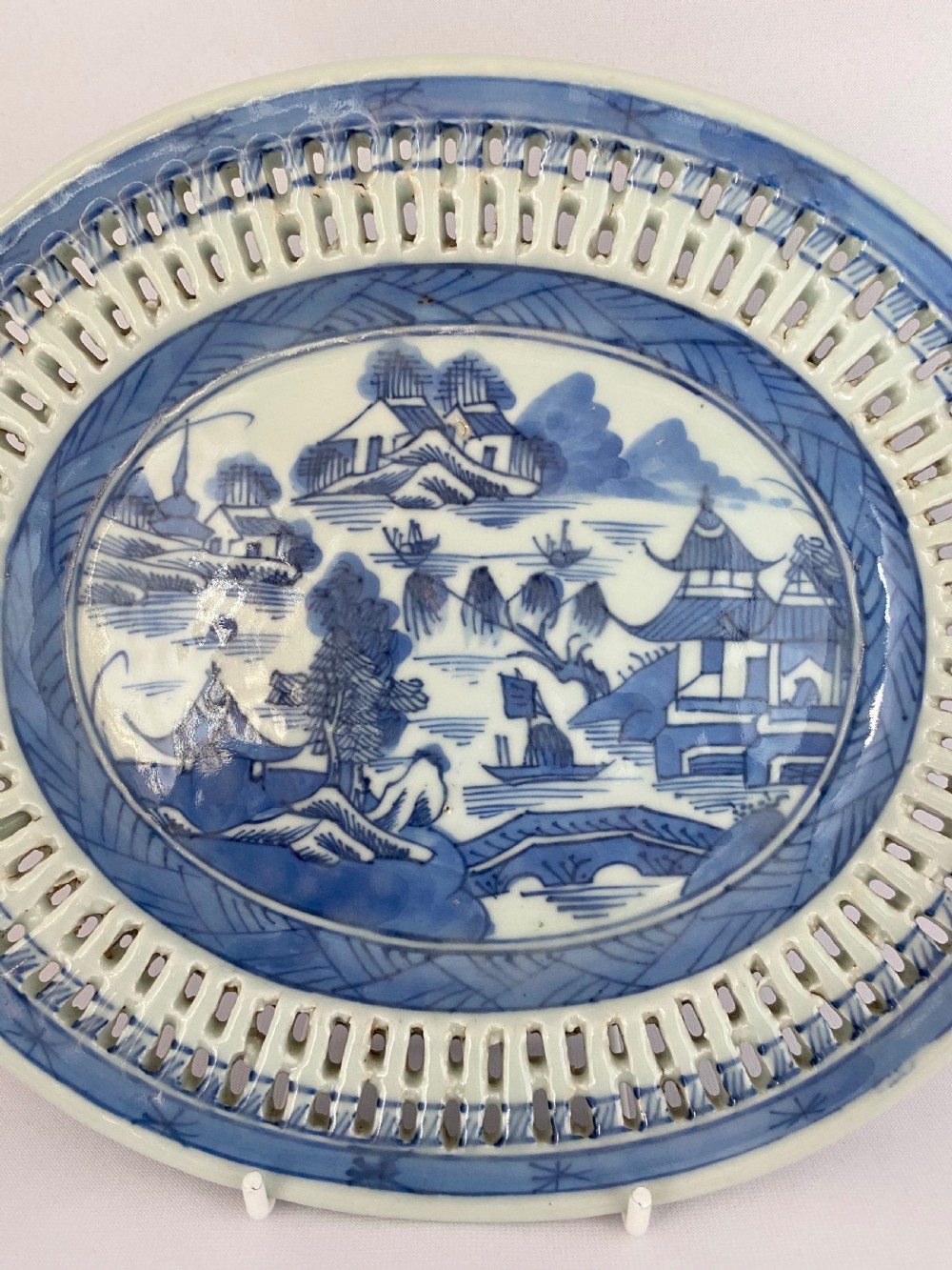 An oval blue and white porcelain Chinese export dish featuring a pierced reticulated border and a hand-painted landscape scene. View II