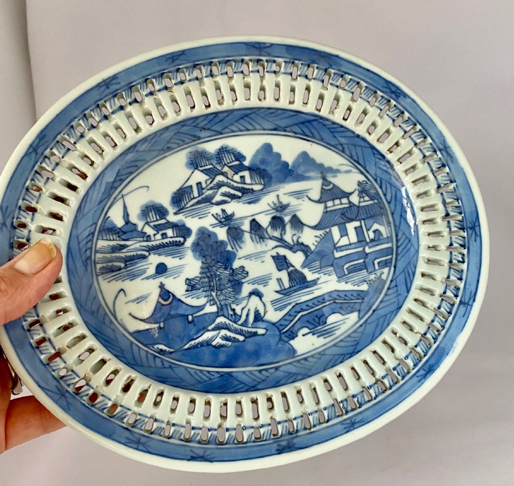 An oval blue and white porcelain Chinese export dish featuring a pierced reticulated border and a hand-painted landscape scene. View IV