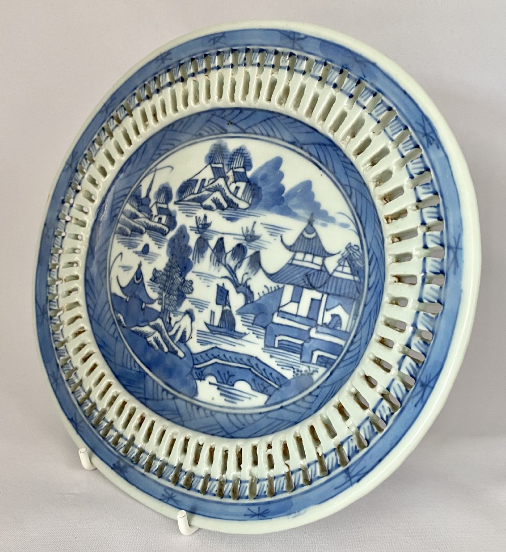 An oval blue and white porcelain Chinese export dish featuring a pierced reticulated border and a hand-painted landscape scene. View V