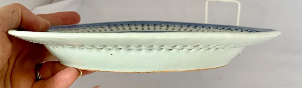 An oval blue and white porcelain Chinese export dish featuring a pierced reticulated border and a hand-painted landscape scene. View VII