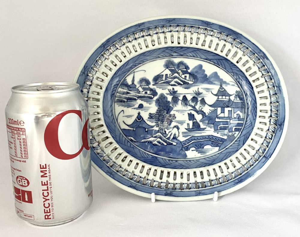 An oval blue and white porcelain Chinese export dish featuring a pierced reticulated border and a hand-painted landscape scene. View IX