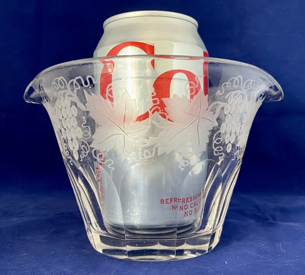 A clear Victorian glass wine rinser featuring acid-etched grapevine decoration around the top edge, dual lip spouts, and a panel-cut lower body. View V