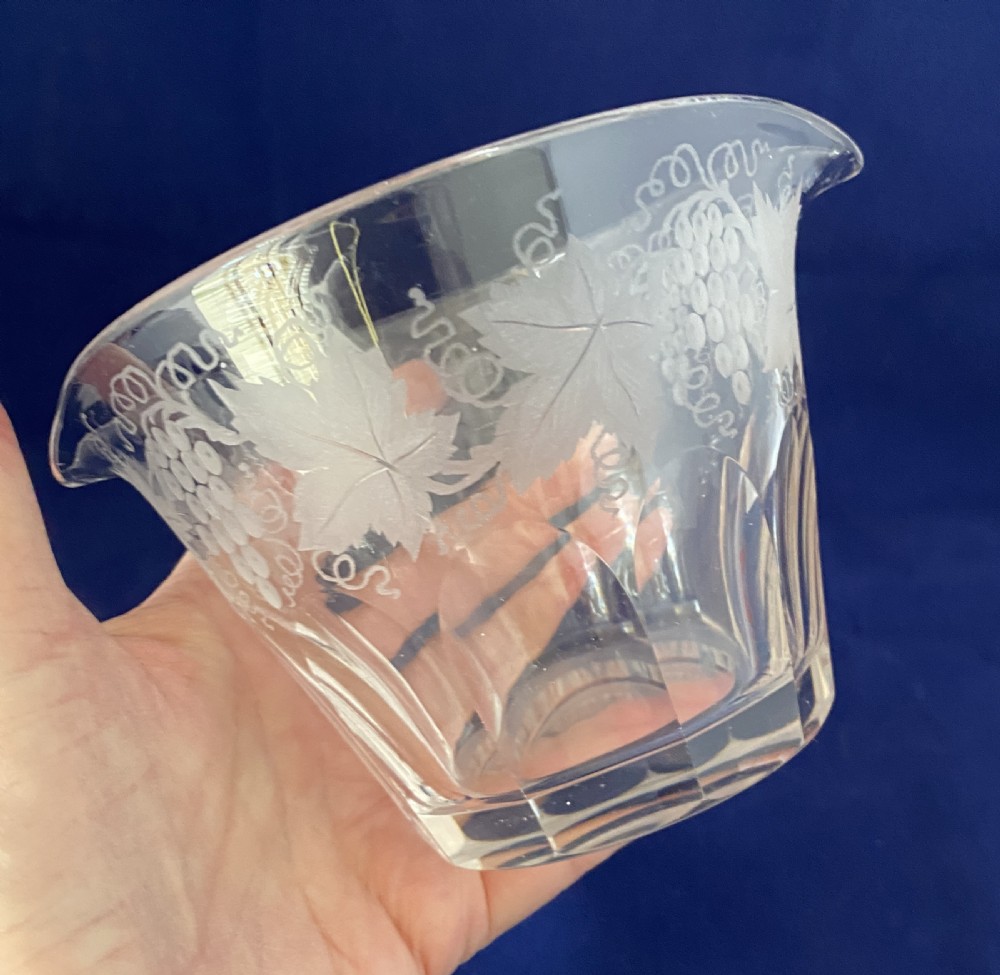 A clear Victorian glass wine rinser featuring acid-etched grapevine decoration around the top edge, dual lip spouts, and a panel-cut lower body. View VII