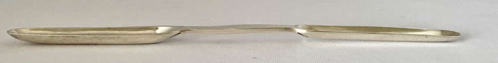 A Victorian double-ended sterling silver marrow scoop with polished elongated bowls resting on a plain background. View VI